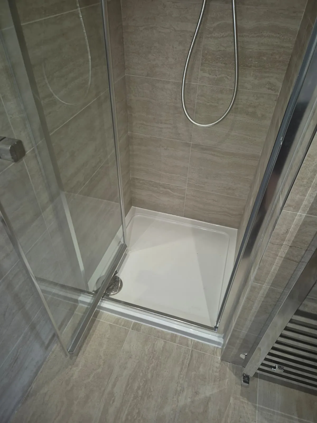 Walk-in shower enclosure with a low-profile tray and glass door fitted by GJS in Essex