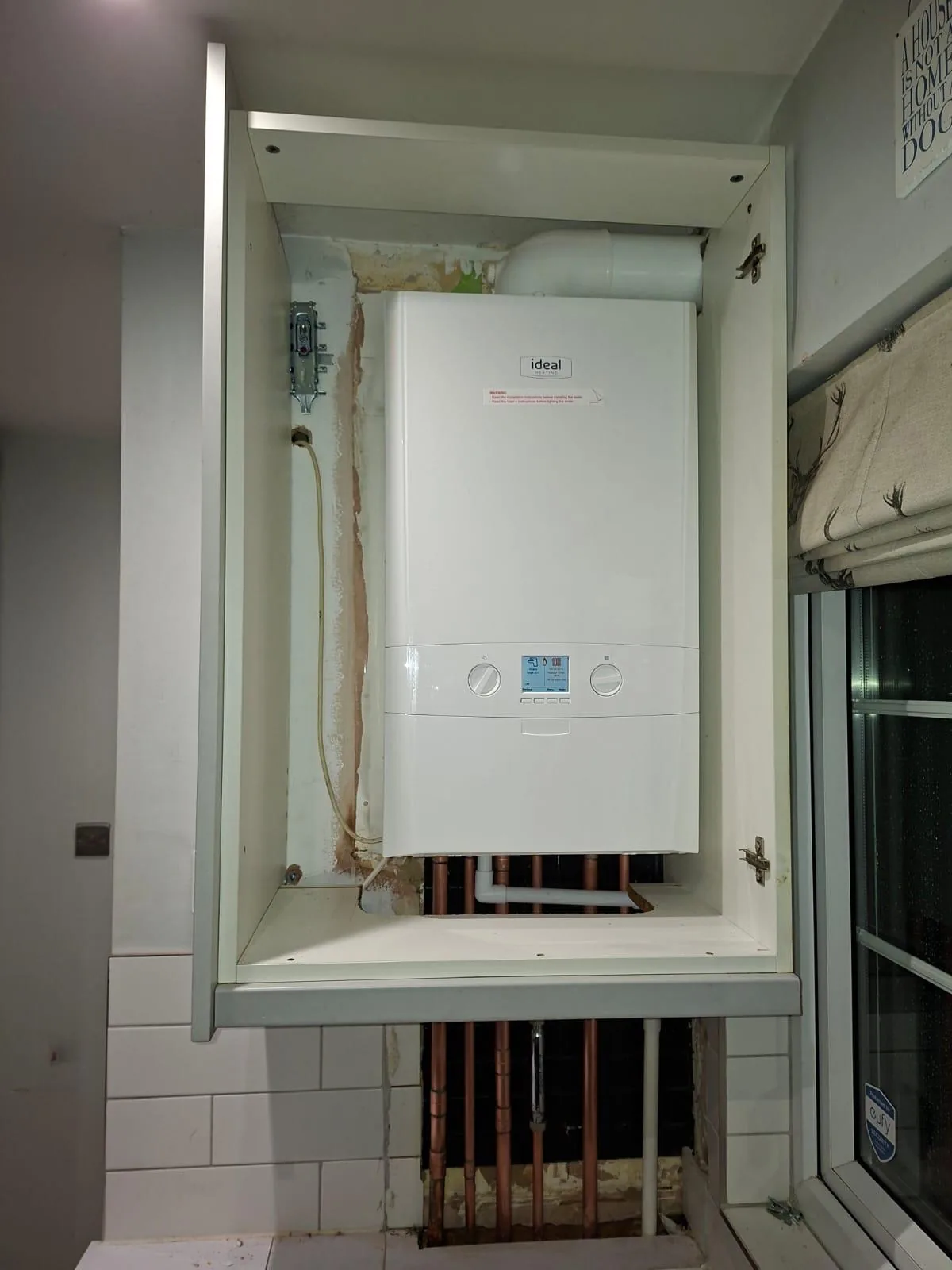 Ideal boiler fitted neatly inside a kitchen cupboard with new copper pipework