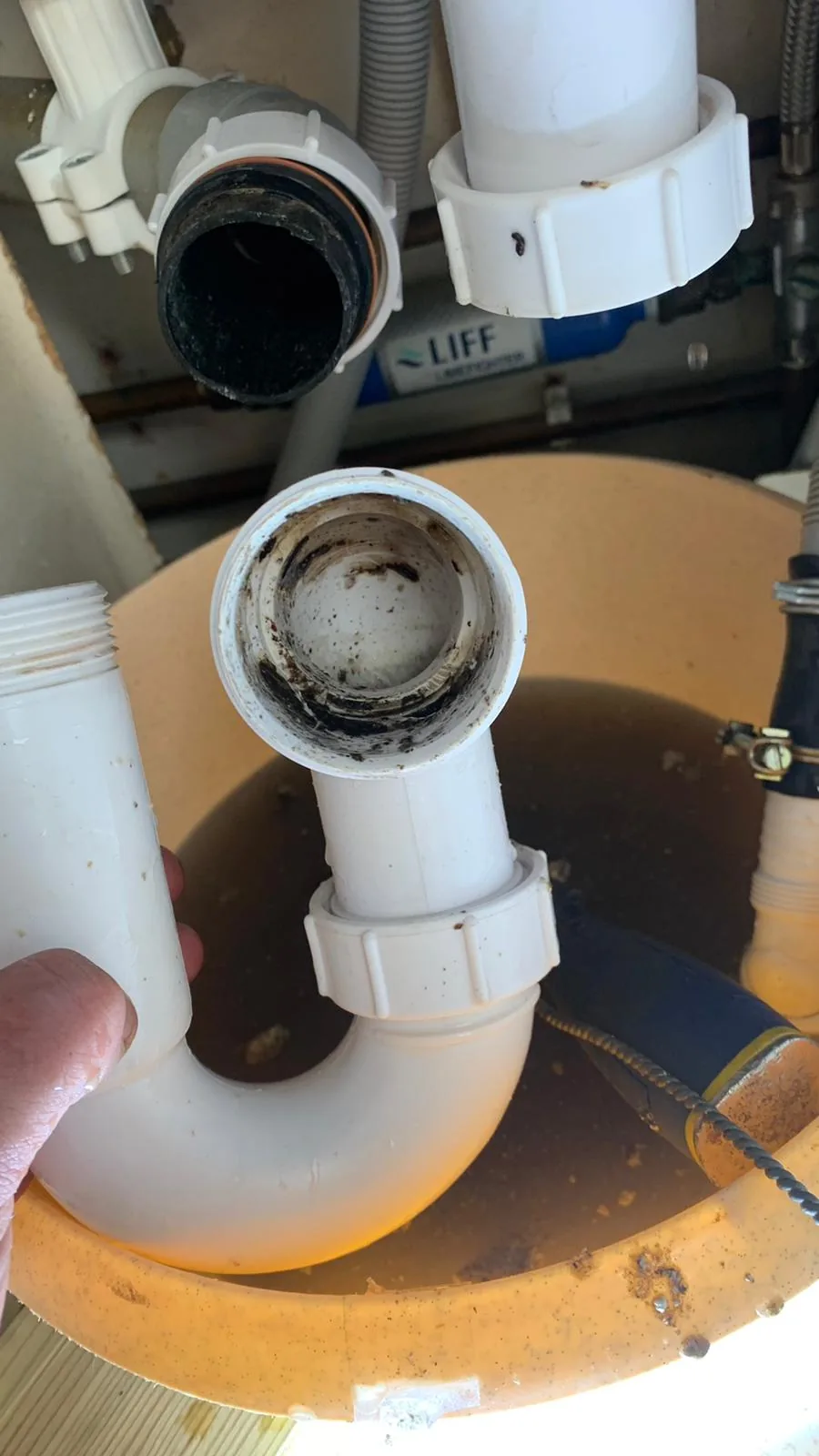Blocked waste trap removed during a plumbing repair